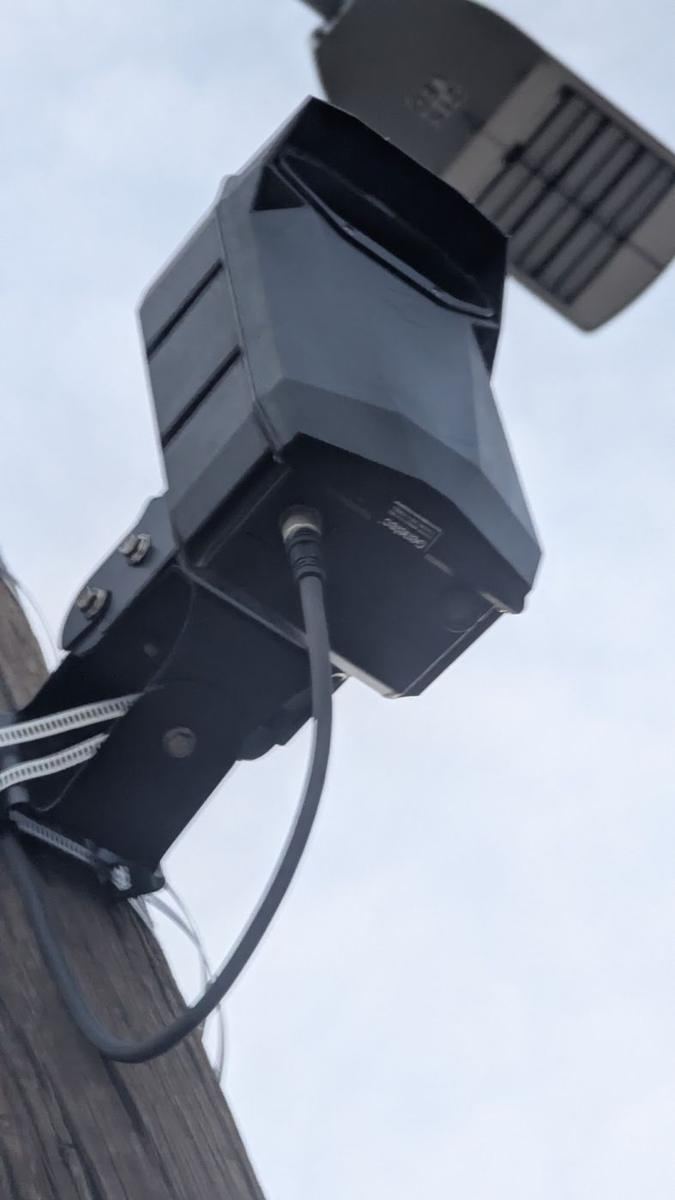 Close-up of a hooded black camera on a bracket